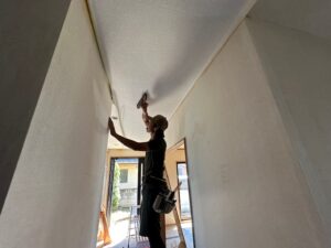 1階玄関、ホールの天井クロス貼りの様子