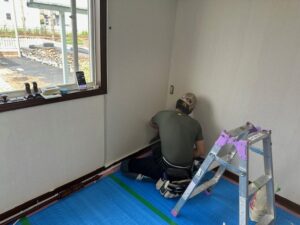 壁のクロス貼り施工中