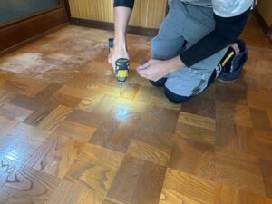 既存床へのビス増し締めで下地を補強する作業