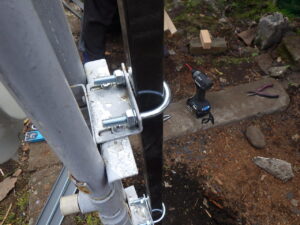 セメントが固まったら、土を被せてU字の金具でガス管とポールを固定していきます。