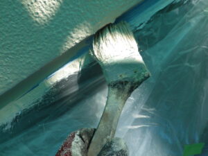 サッシ回りなどを刷毛を使用して塗っている様子。