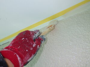 外壁・軒天との取合い塗装を刷毛を使用して行っている様子。