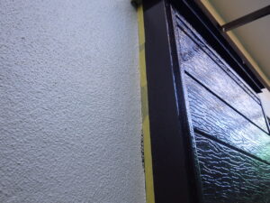 掃除補修を行っていきます。 外壁に戸袋の塗料がついてしまっている部分には、このようにマスキングテープを貼り、補修を進めて行きます。