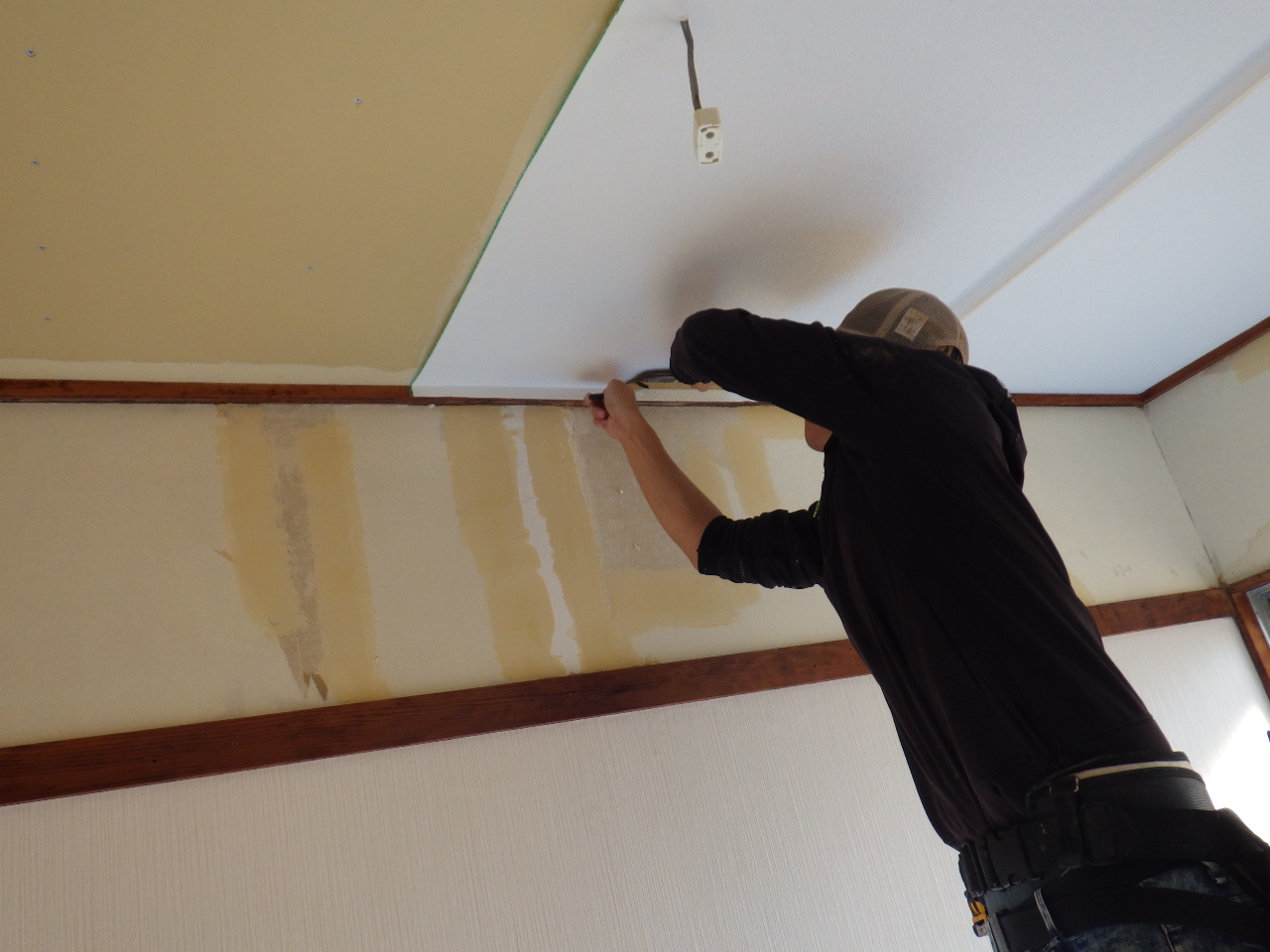天井クロスを貼って仕上げている様子