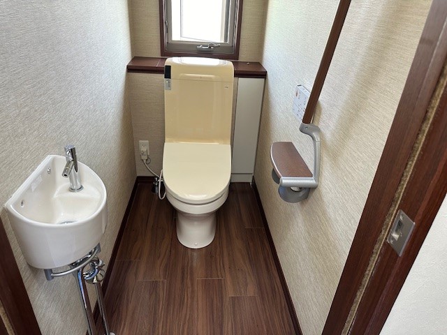 施工前のタンク式トイレ(既存手洗い器・手すりあり)