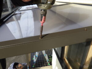 端部垂木カバーを取り付け、屋根パネルの固定している様子になります。