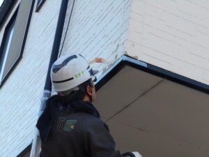 塗膜が剥がれてしまった部分に下塗り材を充慎している様子。