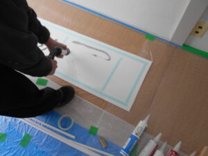 両面テープを貼りコーキングでも充慎を行っている様子。