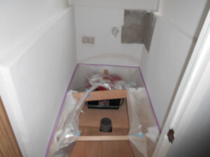 トイレの壁の不陸がすごい為抑えが出来そうな木材でキッチンパネルを抑えていきます。