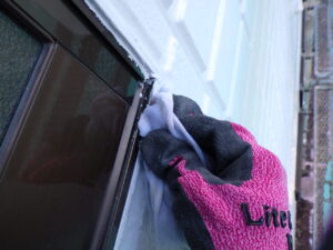 サッシに付いてしまった塗料をトシンで拭き取っています。 