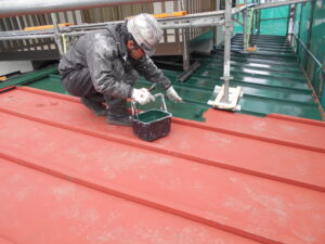 下屋根の中塗りを行っている様子。