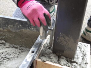 モルタルを打設したあとは、内部に空気が残らないよう、固まる前にしっかりと空気を抜いていきます。 この工程を行うことで、内部の気泡が減り、ひび割れや強度低下のリスクを抑えることができます。 耐久性を高めていきます。