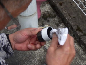 竪樋同士を繋ぐのに、専用接着剤を塗布し、継手を既存の竪樋に取り付けていきます。 