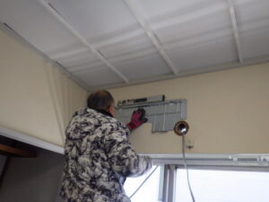 エアコン取り付け作業に移ります。 据付板の位置を確認し、ドレン水がスムーズに流れるように、水平器で確認をしながら、少し傾斜をつけて据付板を取り付けていきます。