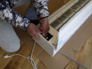 室内機に３芯の配線を接続し、据付板にエアコンを嵌めていきます。