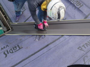 並行して、谷樋の取り付けも行っていきます。 谷樋は、V字型に交差する部分に谷樋を取り付けることで、金属製の板状の雨水排水路になります。