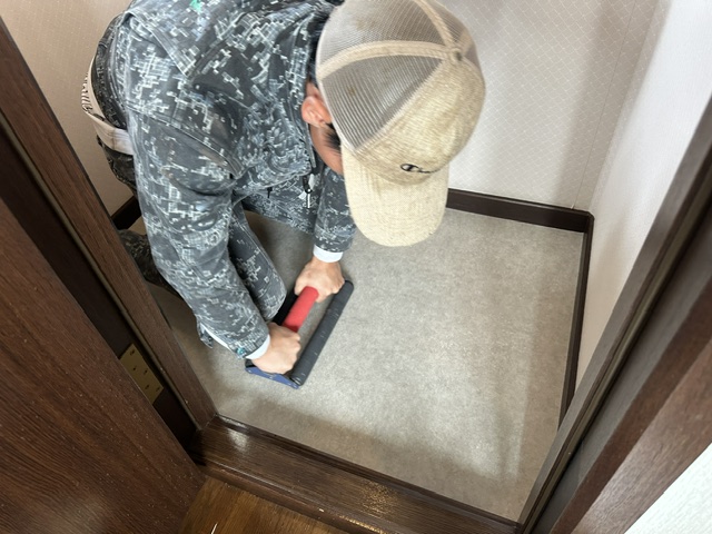 トイレ床のクッションフロアを圧着している様子