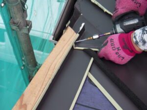 谷樋に重なる部分には電動ハサミで加工を行い、横暖ルーフの張り付けを進めて行きました。