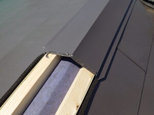 棟板金の繋ぎの部分には、コーキングを塗布し、３０～５０ｍｍ棟板金を被せて取り付けていきます。