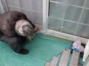 サッシ廻りの養生をしている様子になります。 養生をすることで、塗料が