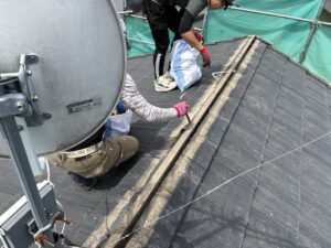棟瓦から解体を進めて行きます。 玄翁やバールを使って、釘を抜き、瓦の取り外しをしていきます。