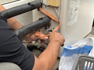 給湯機にハイブリットホースを接続していきます。