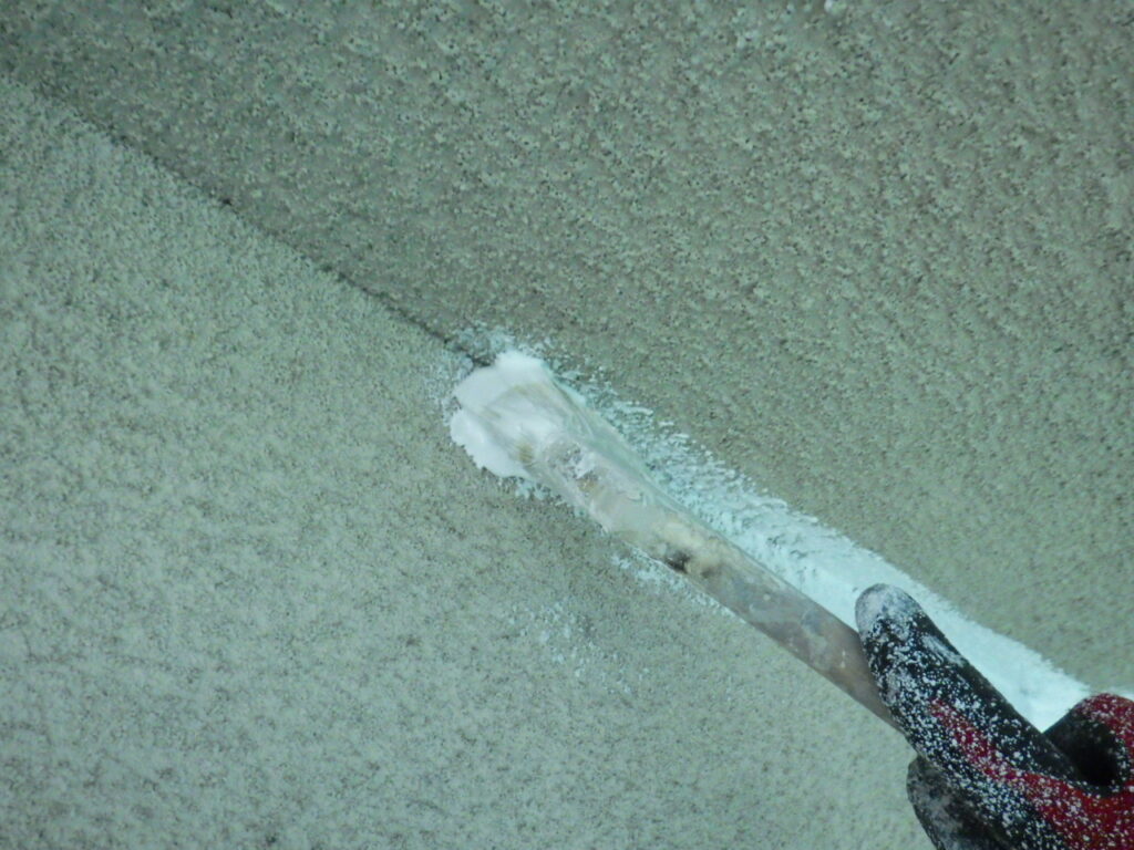 外壁下塗り塗装の作業に移ります。 ローラーが入れにくい、入隅やサッシ廻りなどは、先に刷毛でダメ込みを行っていきます。